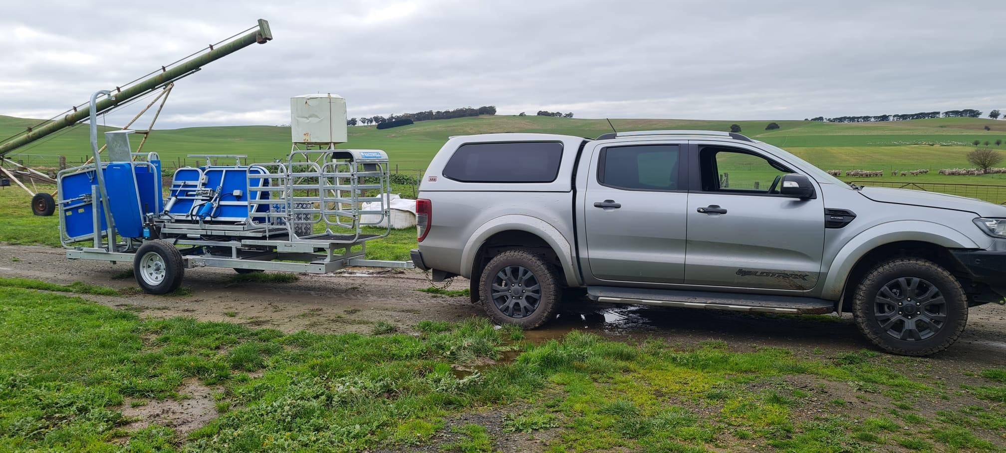 sheep handling trailer being transported between farm yards